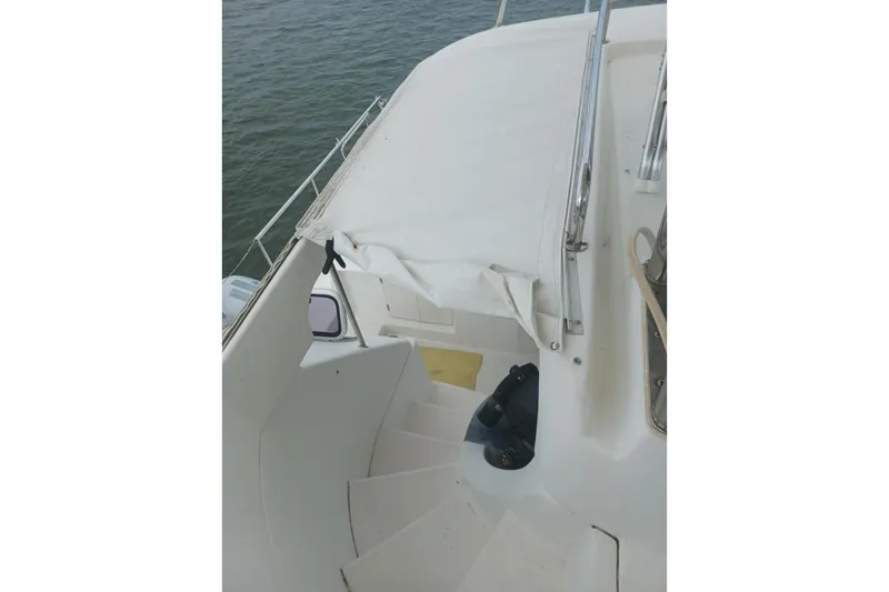Mangata Yacht Photos Pics 2003 Lagoon Power 43 yacht deck with white canopy and stairs, overlooking water.