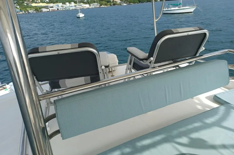 Mangata Yacht Photos Pics Deck chairs on a 2003 Lagoon Power 43 yacht overlooking calm blue waters.