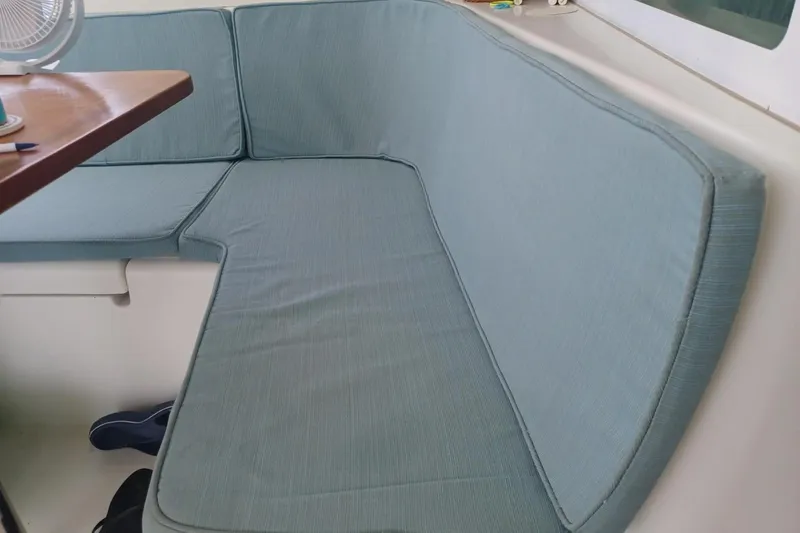 Mangata Yacht Photos Pics Blue cushioned seating area inside a 2003 Lagoon Power 43 boat.