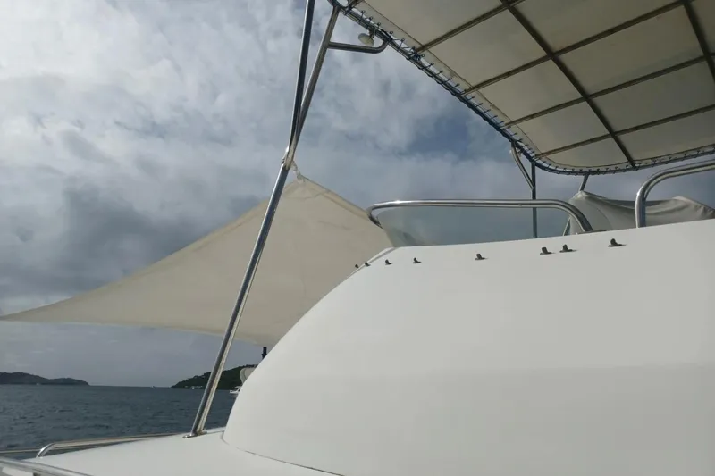 Mangata Yacht Photos Pics 2003 Lagoon Power 43 yacht with canopy, sailing under cloudy skies.