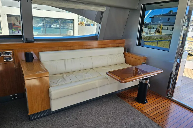 Gramac V Yacht Photos Pics Luxurious interior of 2007 Azzura 76 yacht with cream sofa and wooden table.