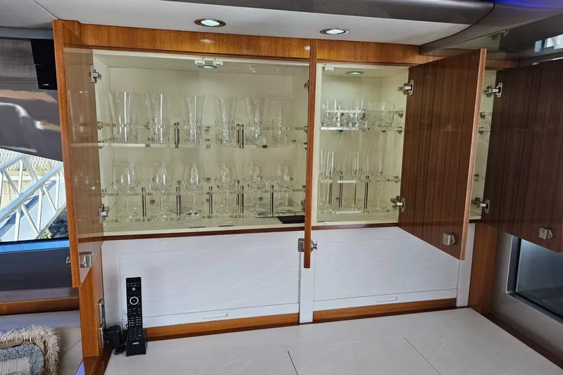 Gramac V Yacht Photos Pics Luxurious glass cabinet in 2007 Azzura 76 yacht interior, showcasing elegant glassware collection.