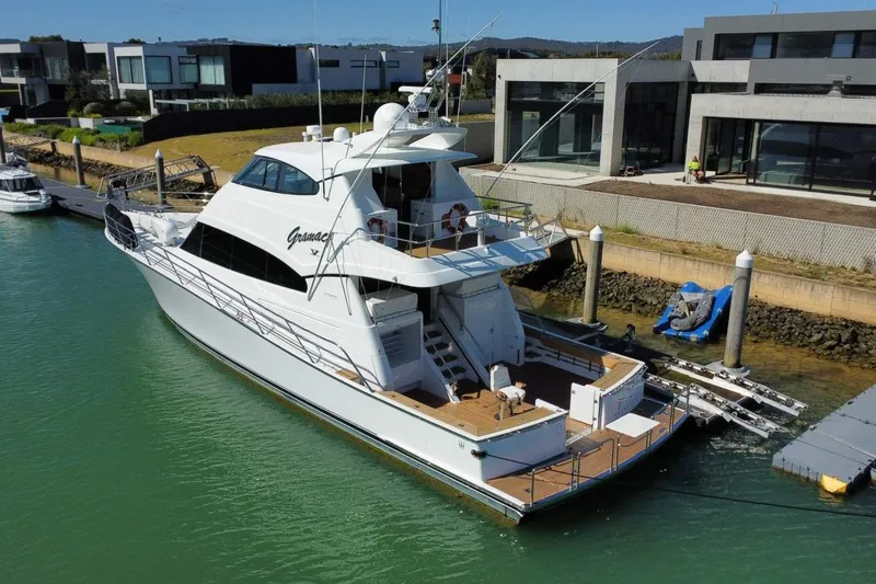 Gramac V Yacht Photos Pics Luxury Azzura 76 yacht docked at marina, 2007 model, modern waterfront homes in background.