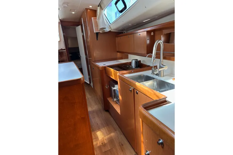 Banyan Sea Yacht Photos Pics Interior of 2008 Beneteau Oceanis 43 yacht, featuring a modern kitchen with wooden cabinetry.