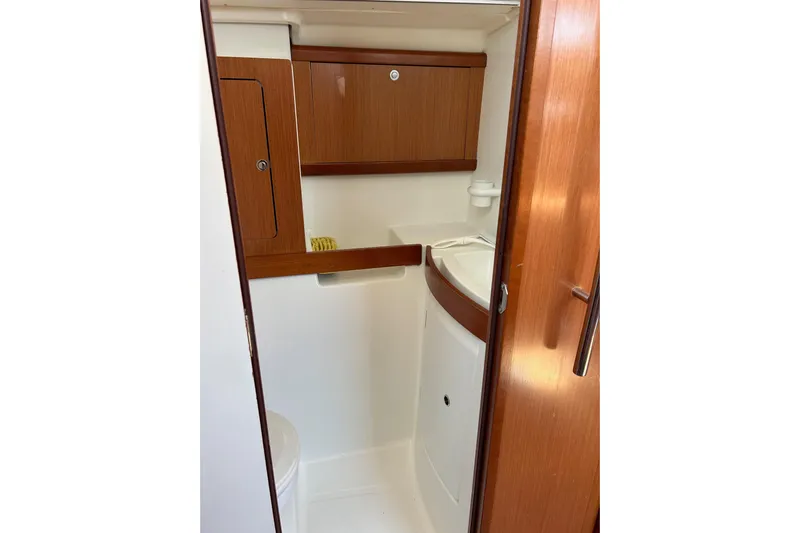 Banyan Sea Yacht Photos Pics 2008 Beneteau Oceanis 43 yacht bathroom with wooden cabinetry and compact design.
