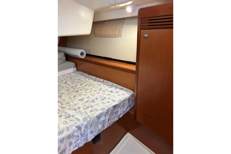 Banyan Sea Yacht Photos Pics Interior cabin of 2008 Beneteau Oceanis 43 yacht with wooden finishes and patterned bedding.