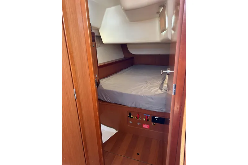 Banyan Sea Yacht Photos Pics Cabin interior of 2008 Beneteau Oceanis 43 sailboat with wooden finish and cozy bed.