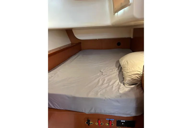 Banyan Sea Yacht Photos Pics Cozy cabin bed in 2008 Beneteau Oceanis 43 sailboat, featuring wooden interior and soft bedding.