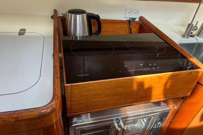 Banyan Sea Yacht Photos Pics Galley kitchen in 2008 Beneteau Oceanis 43 yacht with induction cooktop and kettle.