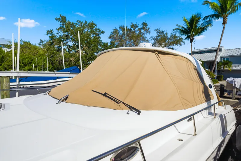 Life Is Good Yacht Photos Pics 2002 Sea Ray 460 Sundancer yacht with tan cover, docked under clear blue sky.