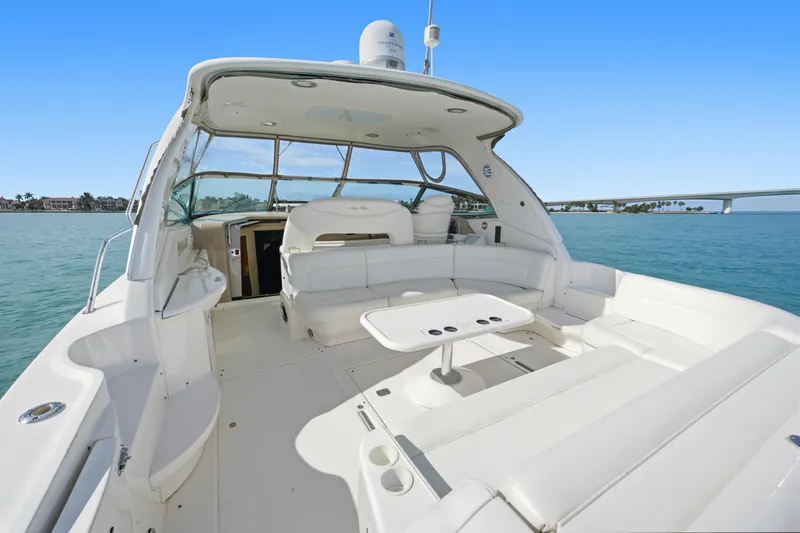 Life Is Good Yacht Photos Pics 2002 Sea Ray 460 Sundancer yacht with spacious deck and seating, cruising on clear blue waters.