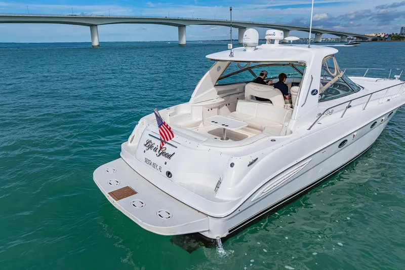 Life Is Good Yacht Photos Pics 2002 Sea Ray 460 Sundancer yacht cruising under a bridge in clear blue waters.