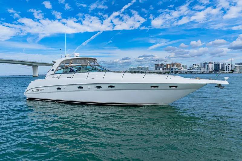 Life Is Good Yacht Photos Pics 2002 Sea Ray 460 Sundancer yacht on calm water with cityscape background.