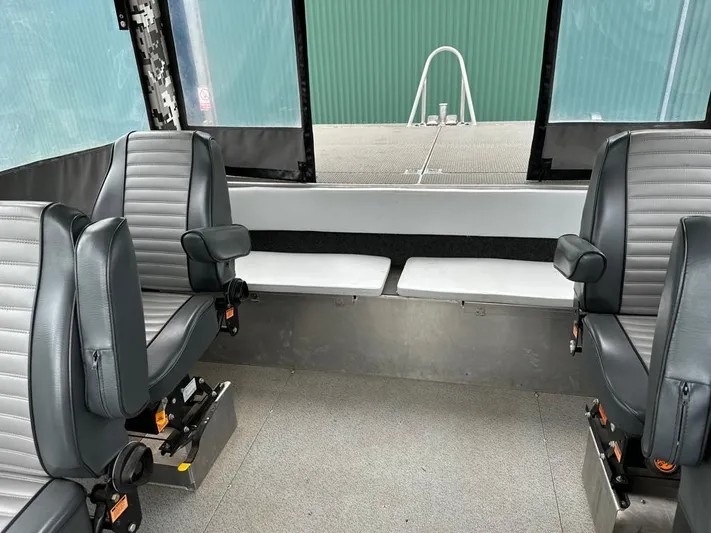 Commander Yacht Photos Pics Interior of a 2014 Wooldridge 31 boat with four grey seats and large windows.