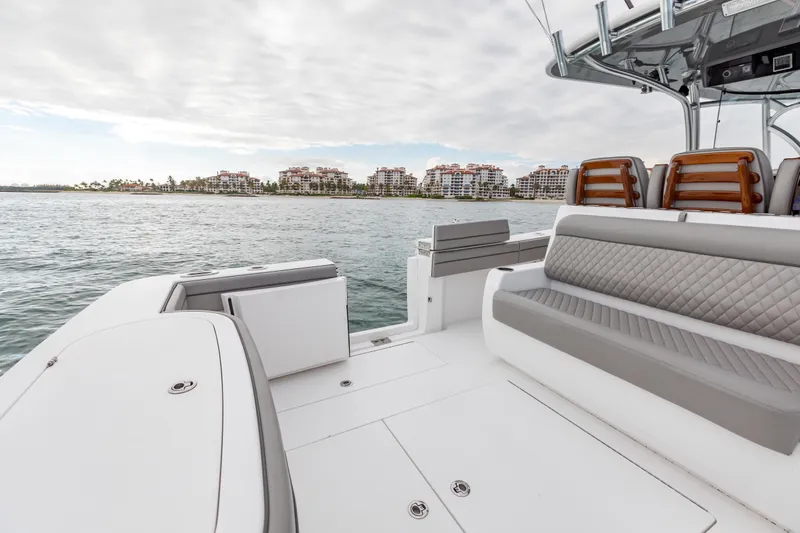 Bank Fees Yacht Photos Pics 2022 Valhalla Boatworks V-41 interior with luxurious seating, ocean view, and coastal buildings.