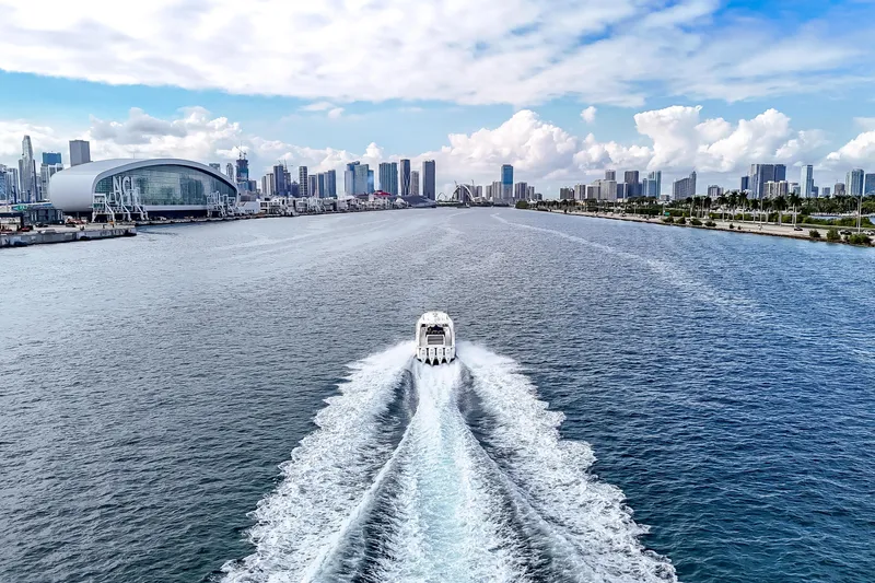Bank Fees Yacht Photos Pics 2022 Valhalla Boatworks V-41 cruising in a scenic urban waterway with city skyline.