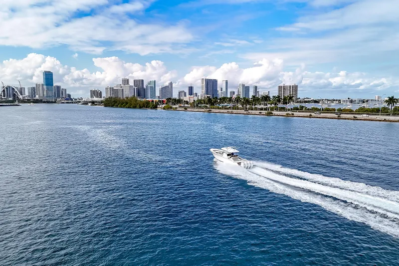 Bank Fees Yacht Photos Pics 2022 Valhalla Boatworks V-41 cruising on blue water with city skyline backdrop.