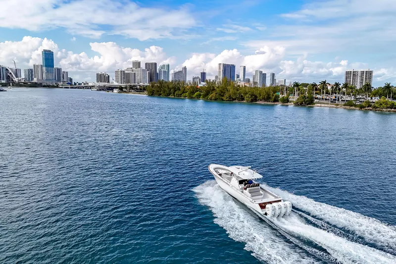 Bank Fees Yacht Photos Pics 2022 Valhalla Boatworks V-41 cruising on a scenic waterfront with city skyline.