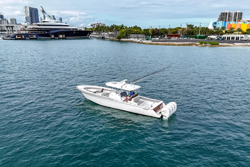 Bank Fees Yacht Photos Pics 2022 Valhalla Boatworks V-41 cruising in a scenic harbor with city skyline backdrop.