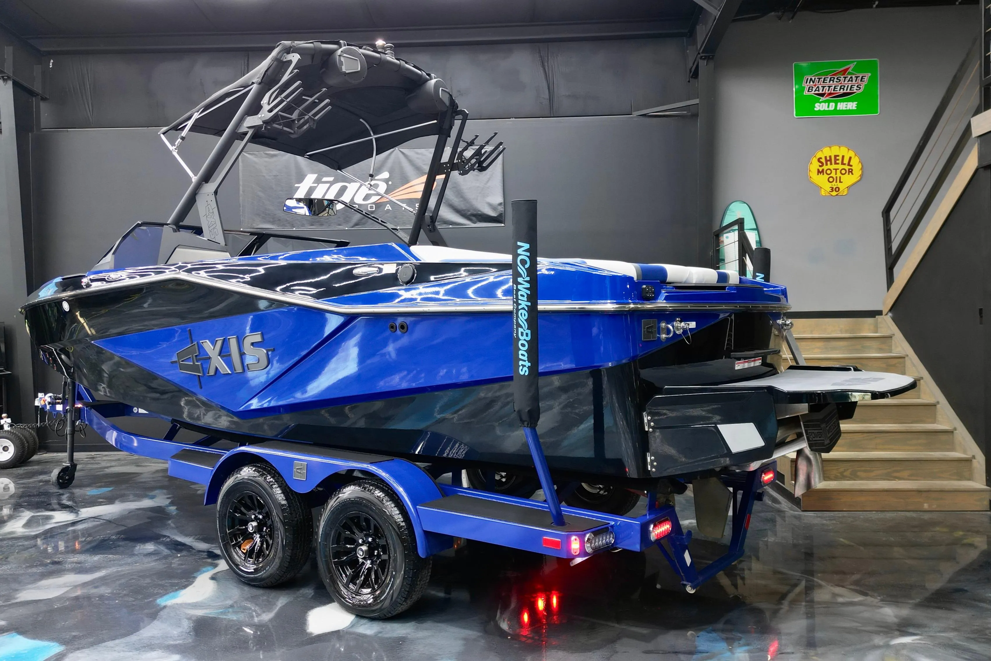 2025 Axis T220 boat in showroom, blue and black design, on trailer.