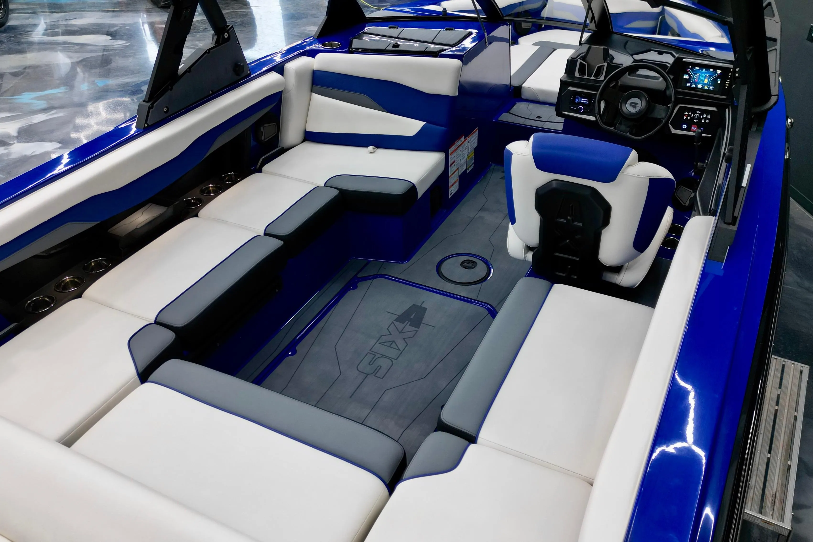2025 Axis T220 boat interior with blue and white seating, modern dashboard, and spacious layout.