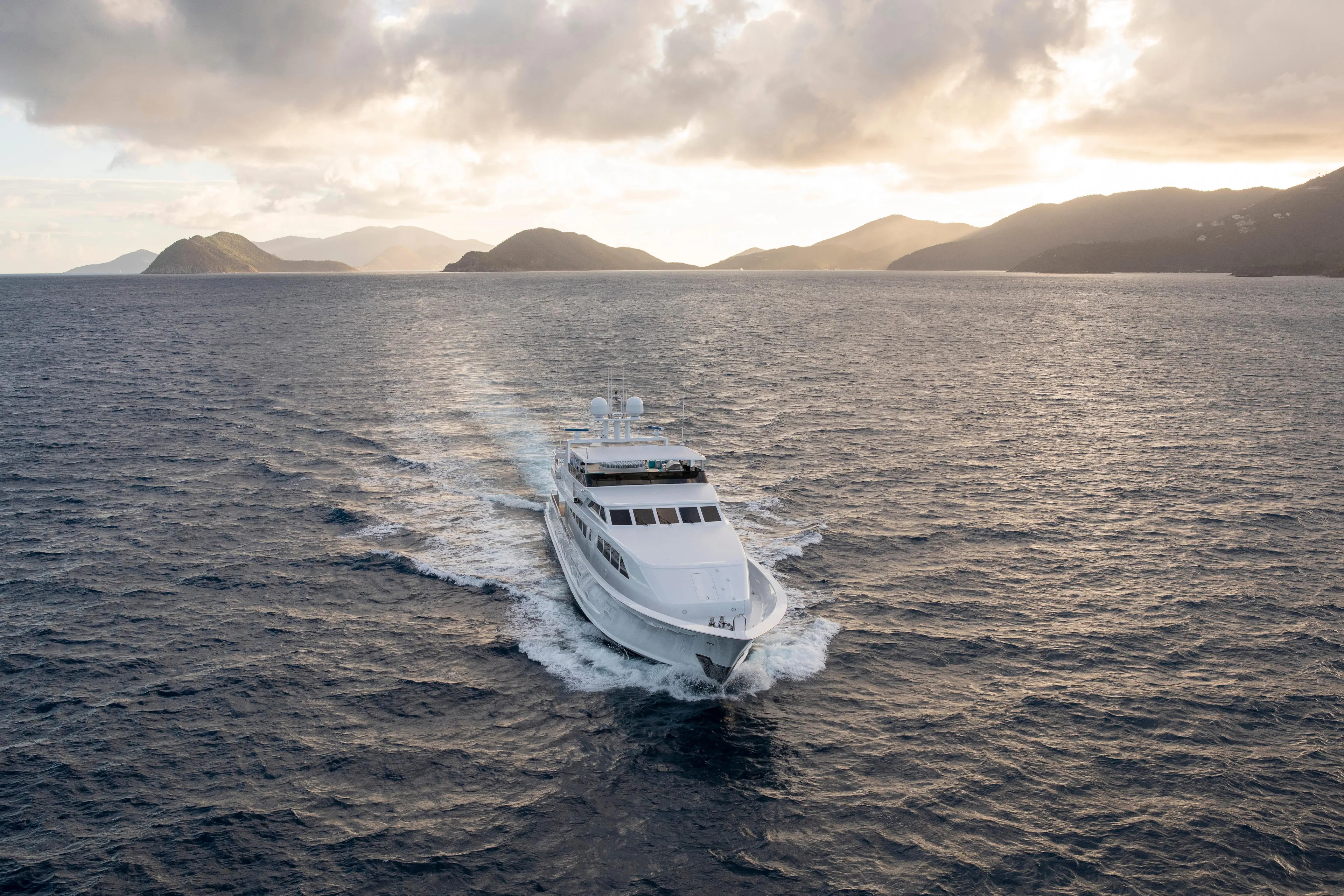  Yacht Photos Pics Luxurious 1994 Broward Marine Raised Pilothouse yacht cruising at sunset near scenic islands.