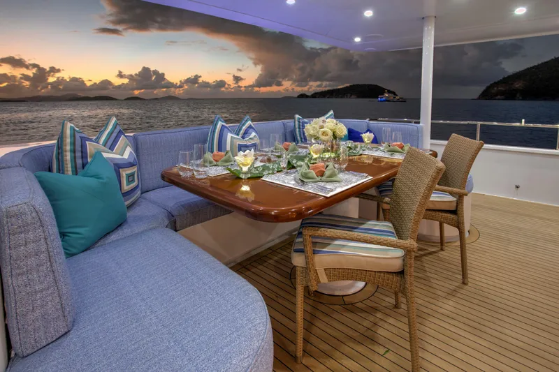  Yacht Photos Pics Luxurious dining setup on 1994 Broward Marine Raised Pilothouse yacht at sunset.