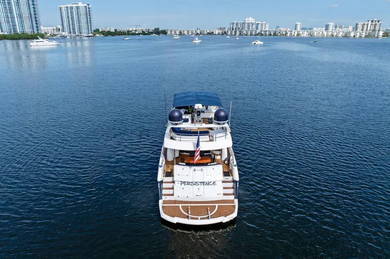 Persistence Yacht Photos Pics 2006 Sunseeker 75 Yacht on calm water with city skyline in background.