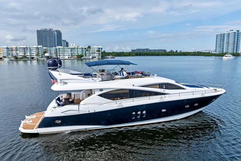 Persistence Yacht Photos Pics 2006 Sunseeker 75 Yacht cruising on a calm waterway with cityscape background.