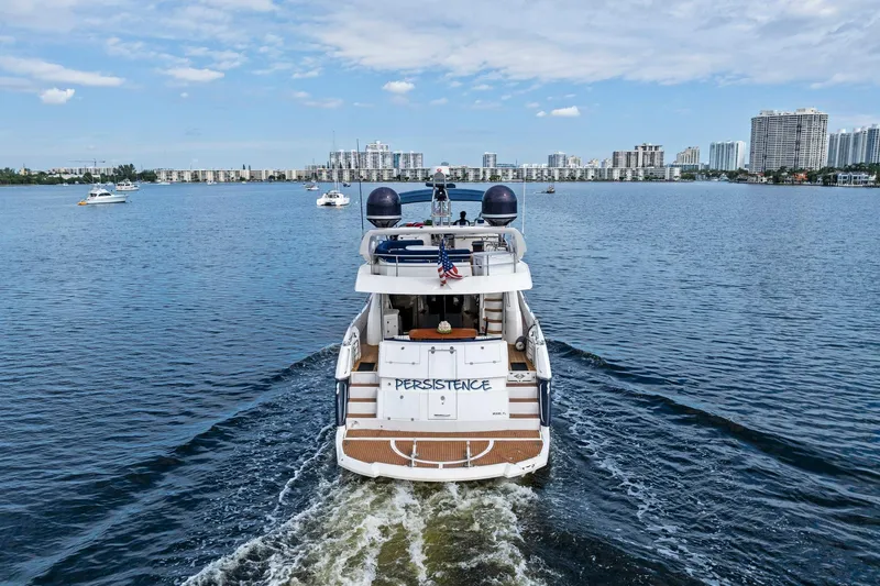 Persistence Yacht Photos Pics 2006 Sunseeker 75 Yacht cruising on a calm waterway with city skyline.