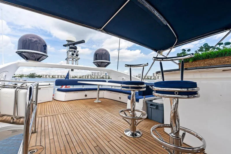 Persistence Yacht Photos Pics Luxurious 2006 Sunseeker 75 Yacht deck with seating and bar stools, under a blue canopy.
