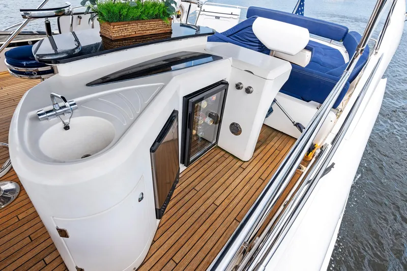 Persistence Yacht Photos Pics Luxurious 2006 Sunseeker 75 Yacht deck with sink, mini-fridge, and seating area.