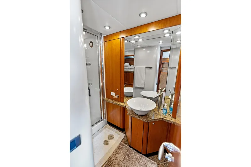 Persistence Yacht Photos Pics Luxurious bathroom in 2006 Sunseeker 75 Yacht with modern fixtures and elegant wood cabinetry.