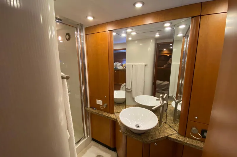 Persistence Yacht Photos Pics Luxurious bathroom in a 2006 Sunseeker 75 Yacht, featuring elegant wood cabinetry and modern fixtures.