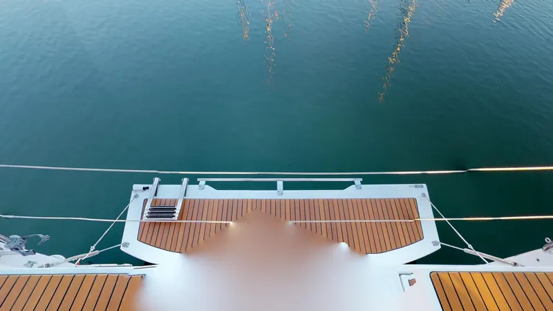 Wanderlust Yacht Photos Pics Beneteau Oceanis 38.1 yacht stern view, 2019 model, with teak deck over calm water.