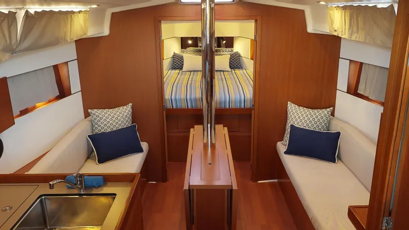 Wanderlust Yacht Photos Pics Interior of 2019 Beneteau Oceanis 38.1 yacht with cozy seating and striped bedding.