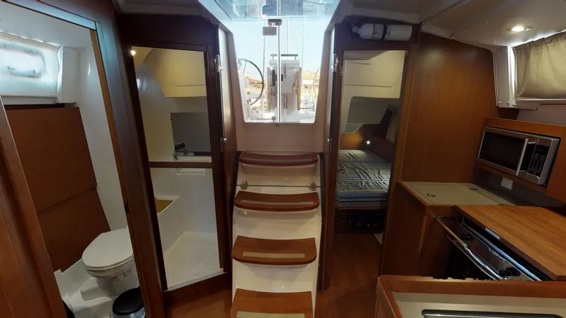 Wanderlust Yacht Photos Pics Interior of 2019 Beneteau Oceanis 38.1 yacht, featuring stairs, cabin, and kitchenette.