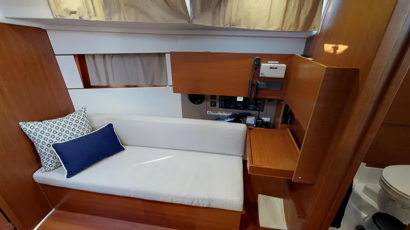 Wanderlust Yacht Photos Pics 2019 Beneteau Oceanis 38.1 interior with sofa, cushions, and navigation station.