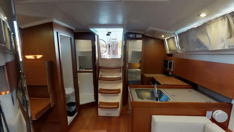 Wanderlust Yacht Photos Pics Interior of 2019 Beneteau Oceanis 38.1 yacht, featuring modern kitchen and wooden cabinetry.