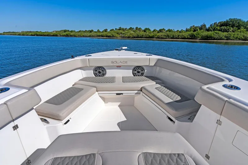  Yacht Photos Pics 2025 Solace 32 CS boat interior with cushioned seating, on a calm waterway.