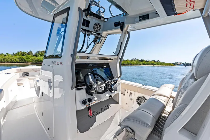 Yacht Photos Pics 2025 Solace 32 CS boat interior with modern helm, steering wheel, and seating, on a sunny day.