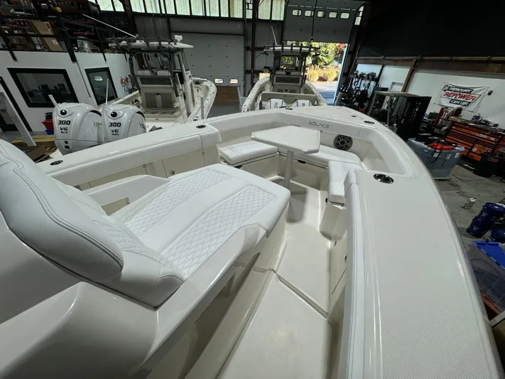  Yacht Photos Pics 2025 Solace 32 CS boat interior with white seating and modern design in a showroom.