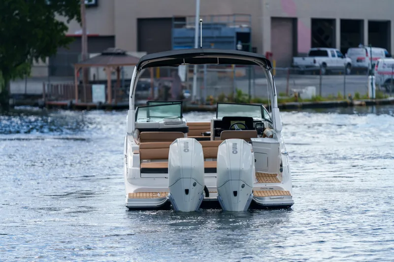  Yacht Photos Pics Rear view of a Sea Ray boat with dual outboard engines on the water.
