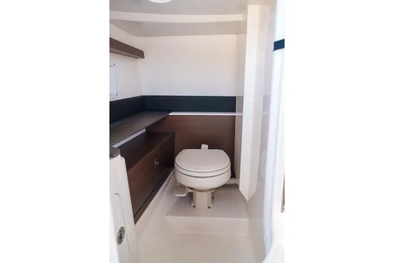  Yacht Photos Pics Compact Sea Ray boat bathroom with toilet and wooden cabinetry.