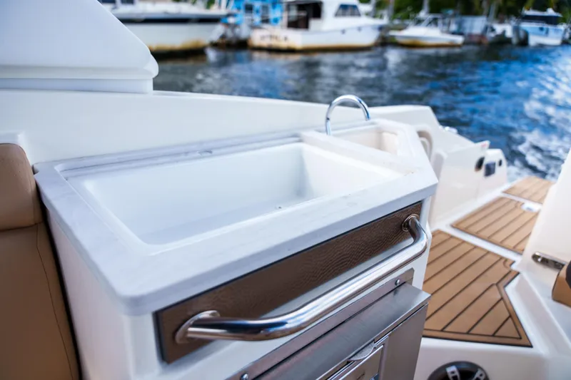  Yacht Photos Pics Sea Ray boat interior with sink and wooden deck, docked near other boats.