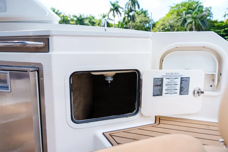  Yacht Photos Pics Open storage compartment on a Sea Ray boat with wooden deck and stainless steel features.