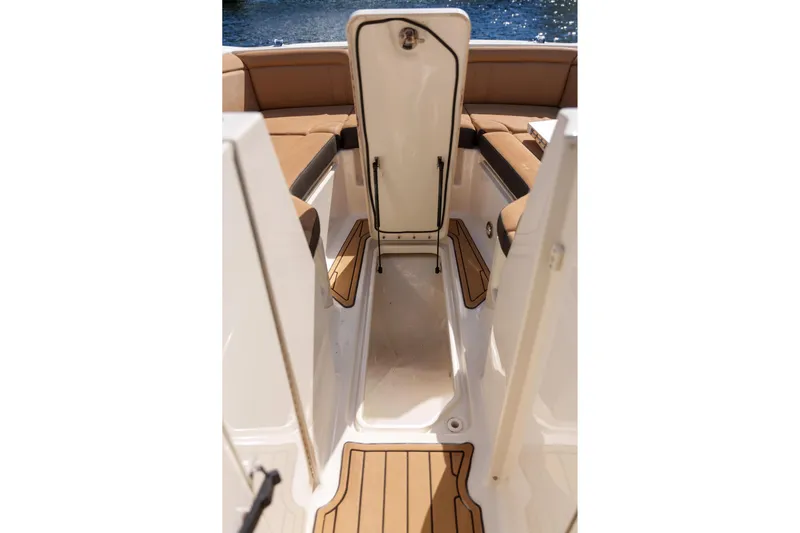  Yacht Photos Pics Interior view of a Sea Ray boat with tan seating and open storage compartment.