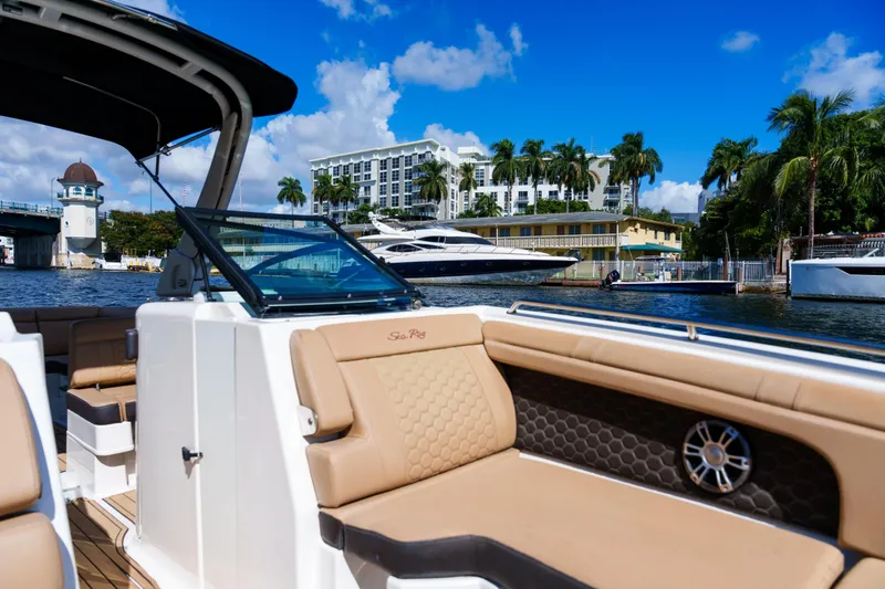  Yacht Photos Pics Luxurious Sea Ray boat interior with waterfront view, palm trees, and blue sky.