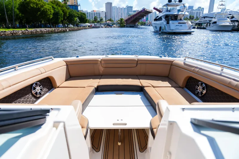  Yacht Photos Pics Luxurious Sea Ray boat interior with tan seating, cruising in a scenic marina.