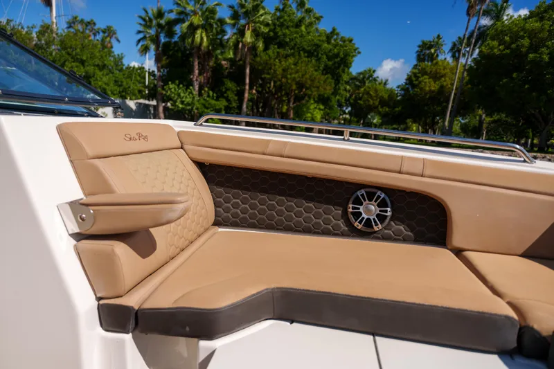  Yacht Photos Pics Luxurious Sea Ray boat seating with tan upholstery and speaker, surrounded by lush greenery.
